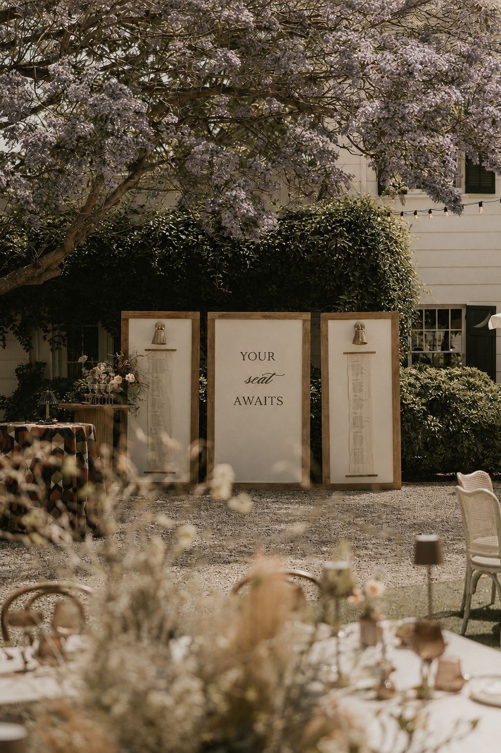 Elegant outdoor seating chart display beneath a blooming jacaranda tree